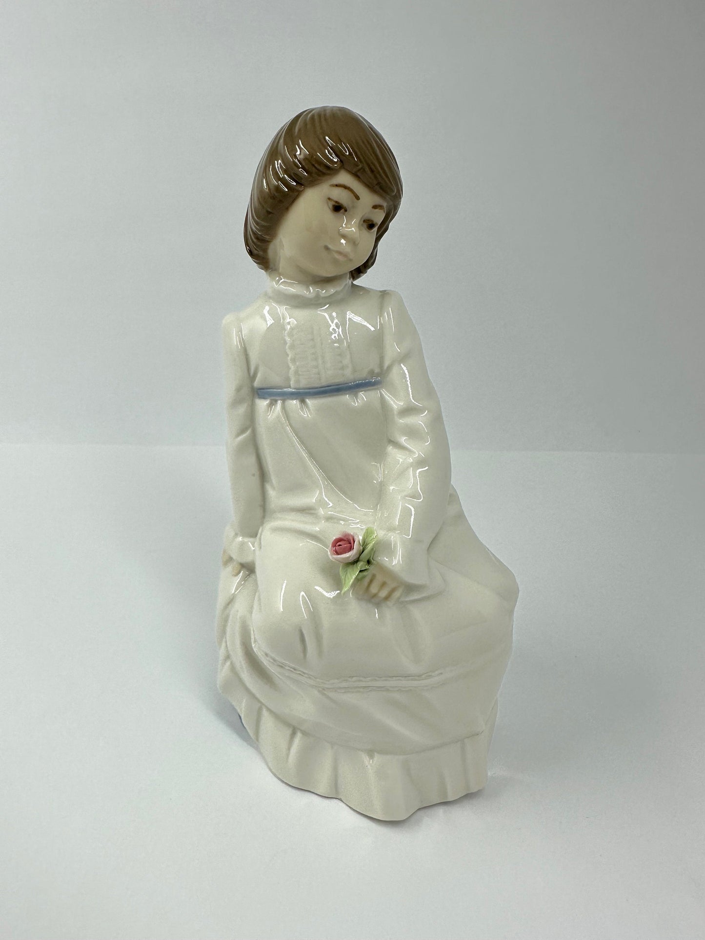 Vintage Porcelain Figurine of Young Girl Sitting Holding a Flower, by Enrique G Nadal.