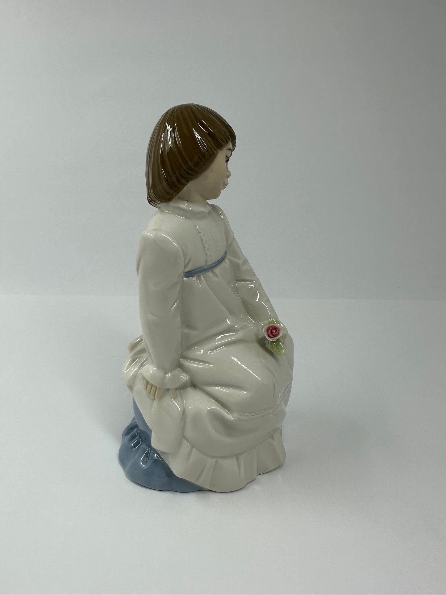 Vintage Porcelain Figurine of Young Girl Sitting Holding a Flower, by Enrique G Nadal.