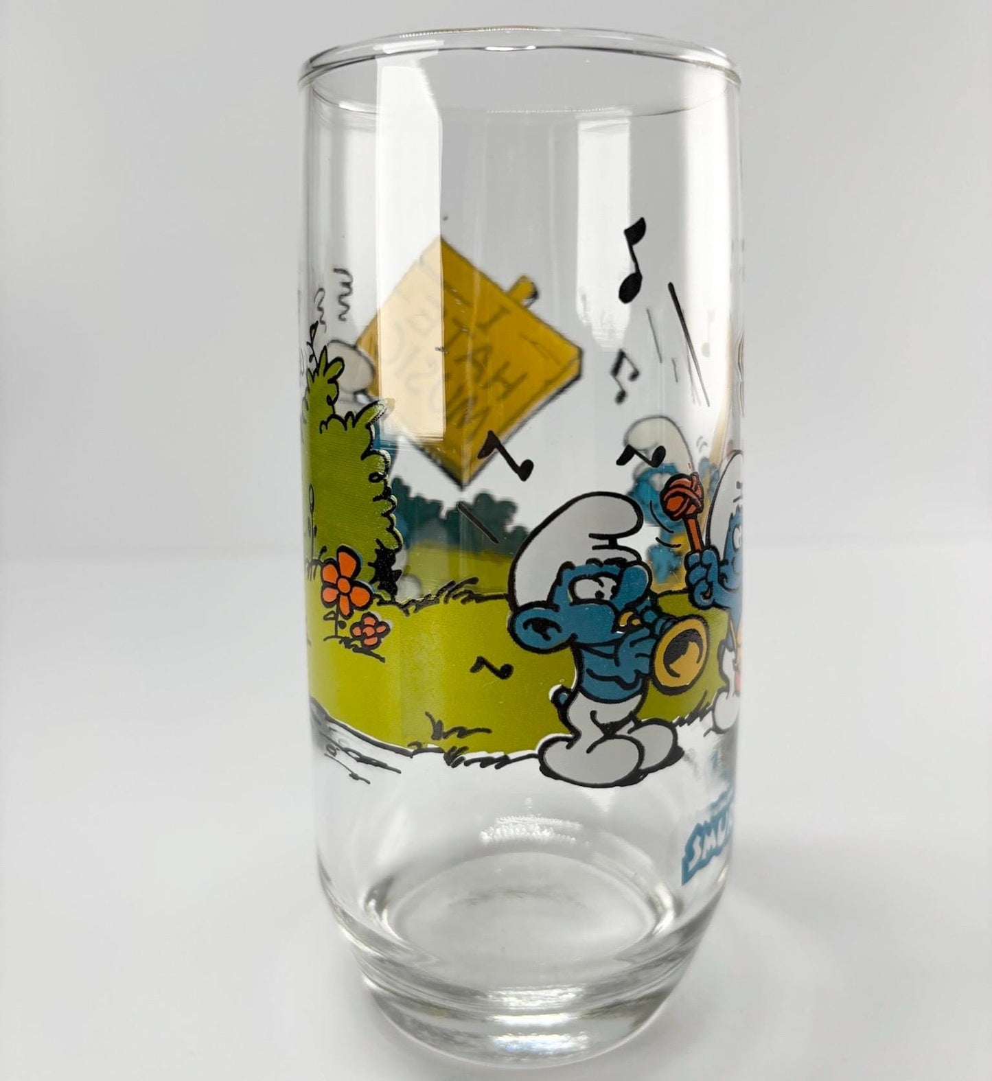 Vintage Glass of Grouchy Smurf Holding 'I Hate Music' Sign 1983